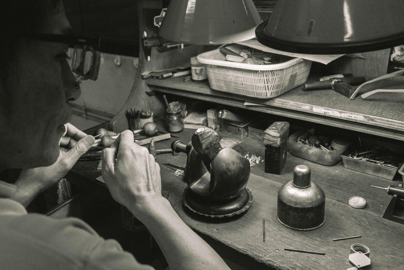 Black and white photo of a craftsman working with tools in a Bangkok workshop.